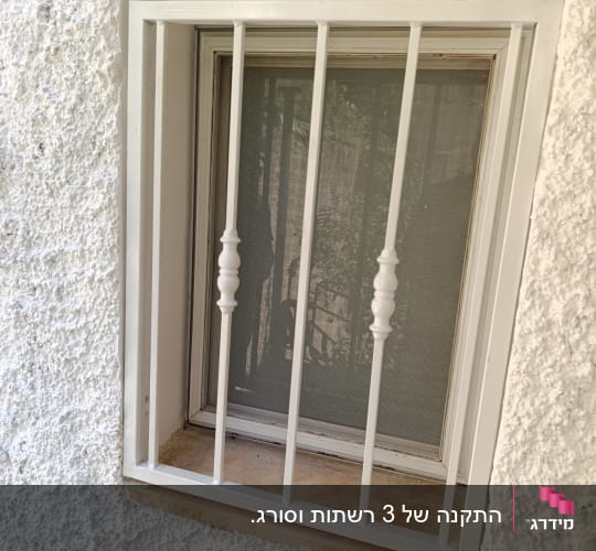 חלון עם סורגי אלומיניום על קיר לבן